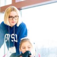 Student instructing two children in the classroom